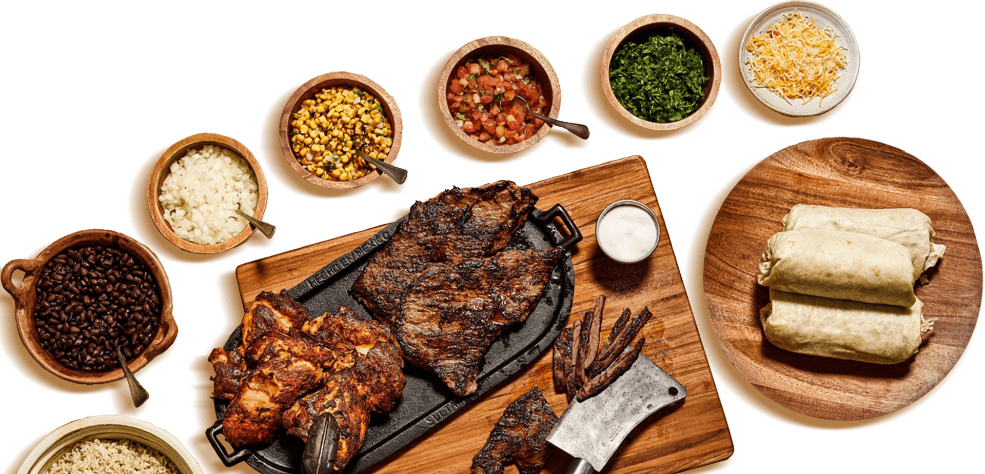 Burrito ingredients in bowls and op top of a cutting board